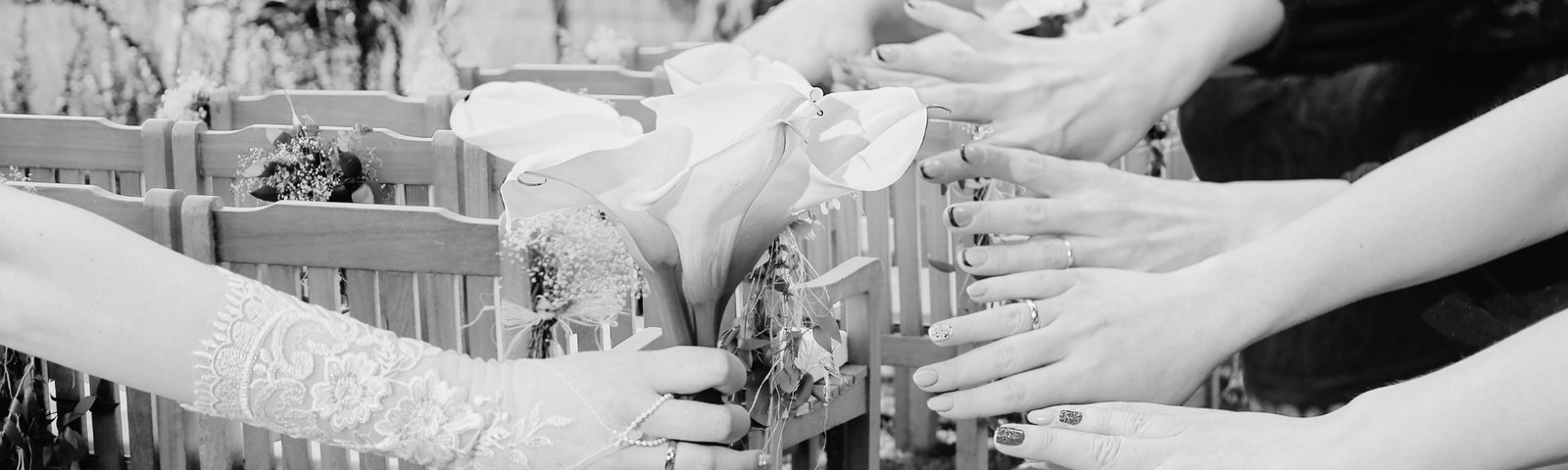 Mains tendues autour d’un bouquet de callas, illustrant un rituel de cérémonie laïque personnalisé, mis en scène par l’Agence Moment de Grâce.