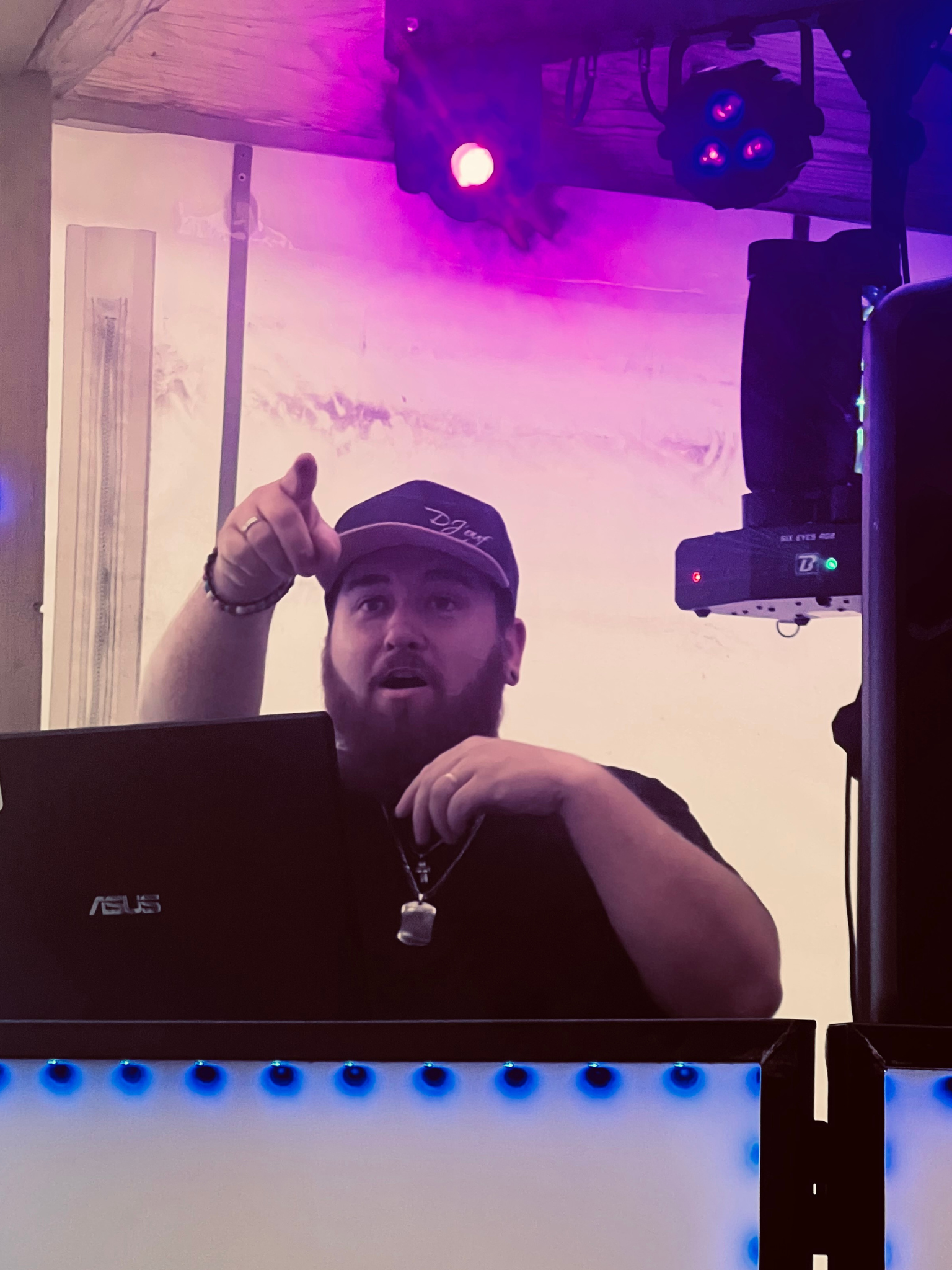 DJ en pleine animation derrière sa régie, éclairages colorés et ambiance festive lors d’une soirée en Bretagne.