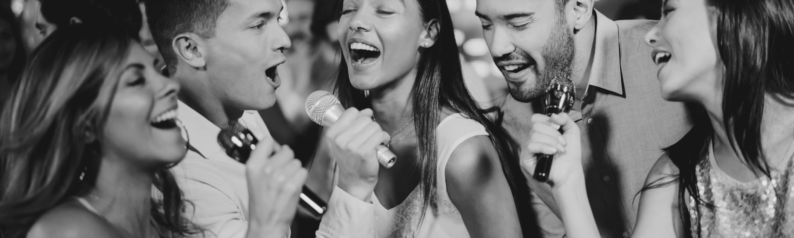 Groupe d’amis chantant au micro lors d’une animation karaoké en Bretagne.