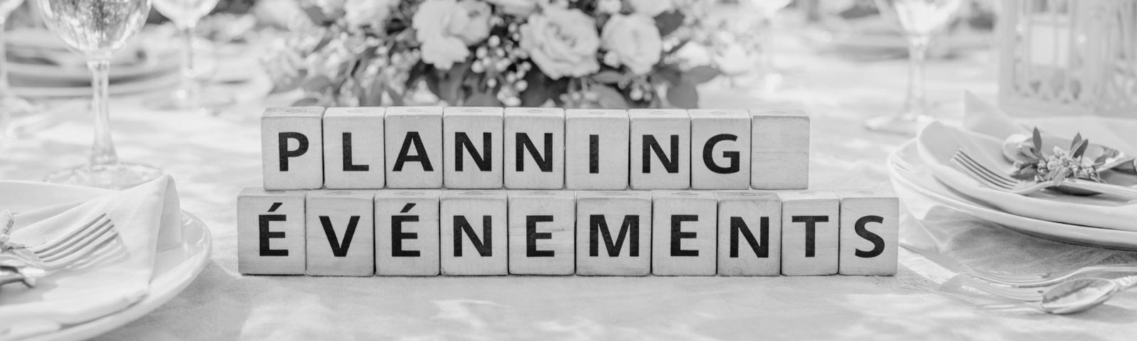 Table de mariage élégante avec décoration florale et cubes en bois formant le mot planning événements, symbolisant l’organisation d’un mariage par l’Agence Moment de Grâce en Bretagne.